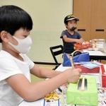 世界に一つだけの輪ゴムのギターを作る子どもたち＝青山公民館