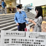 通行人に情報提供のビラを配る警察官ら＝神戸電鉄志染駅前