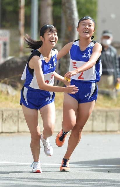 女子・三木の３区藤田心音選手（左）にリレーする２区田丸樹選手＝西脇市総合市民センター（撮影・笠原次郎）