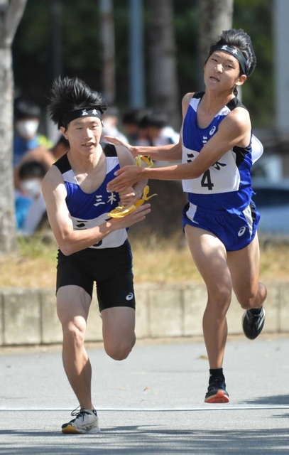 男子・三木の４区横山幹太選手（右）からたすきを受け取る５区畑中晟希選手＝西脇市総合市民センター（撮影・笠原次郎）