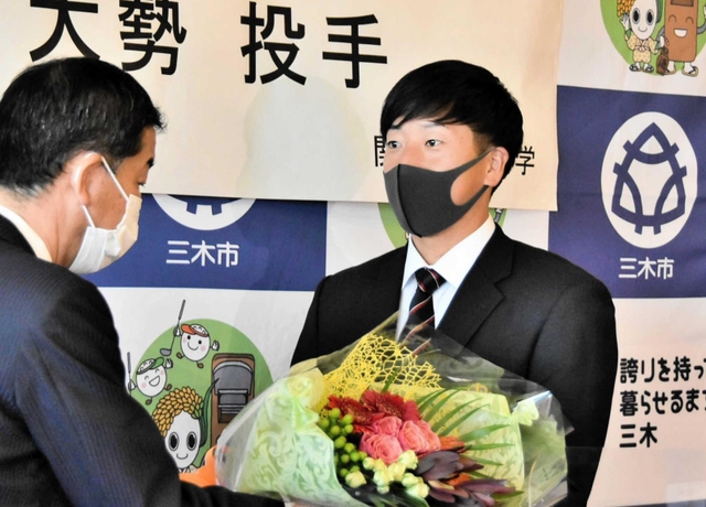 仲田一彦市長（左）から花束を贈られる翁田大勢投手＝三木市役所