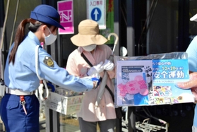 啓発グッズを配布する三木署員ら＝三木市志染町青山３