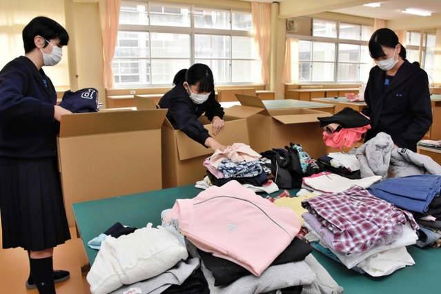 集まった衣服を段ボールに詰める生徒ら＝三木北高校