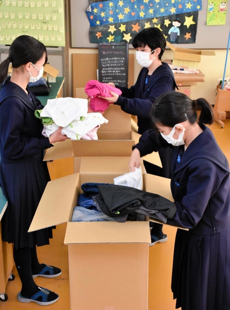 集まった衣服を段ボールに詰める生徒ら＝三木北高校