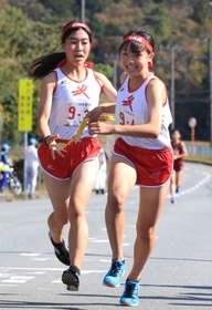 女子・小野の３区松原ちよ選手（左）からたすきを受け取る４区竹内日彩選手＝丹波篠山市内（撮影・吉田敦史）