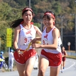 女子・小野の３区松原ちよ選手（左）からたすきを受け取る４区竹内日彩選手＝丹波篠山市内（撮影・吉田敦史）