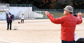 人と人との間隔を空けて大声で歌う参加者ら＝三木山総合公園陸上競技場（三木市文化会館提供）