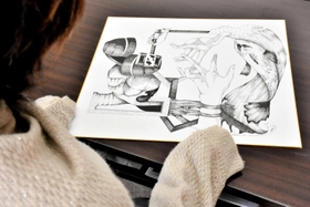 新しく描いた作品の意味を説明するめぐみさん＝三木市細川町細川中