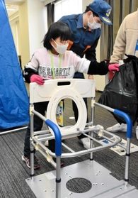 簡易トイレを組み立てる女児＝関西国際大