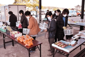 公民館の軒先に並べられた商品を選ぶ地域住民＝口吉川町公民館