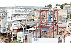 再建工事開始。大型クレーンで赤い鉄骨が持ち上げられ、駅の骨組みが姿を現し始めた（２０２１年１１月）＝三木市末広１