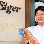 昨春に移転したアイガー加東店でもち麦パンを持つ西嶋直也さん＝加東市上中１
