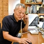 電話で寄せられた相談に対応する岩崎吉男さん＝三木市久留美