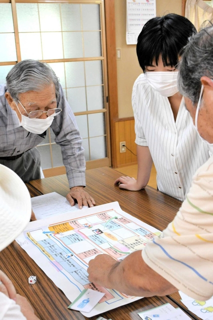 藤本幸音さんらが製作した防災すごろくを楽しむ地域住民ら＝三木市宿原