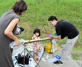 流しそうめんを楽しむ親子＝三木市志染町三津田（ＮＰＯ法人ほっぺ提供）