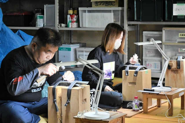 真剣な表情で金属板と向かい合う野村さん（手前）と杉本さん＝三木市別所町高木