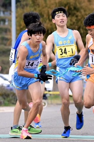 男子・緑が丘の１区幸田海心選手（右）からたすきを受け取る２区岡田潤選手＝豊岡市日高町（撮影・斎藤雅志）