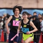 女子・三木市の１区横田歩選手（左）からたすきを受ける２区屋敷萌子選手＝加古川河川敷マラソンコース（撮影・笠原次郎）