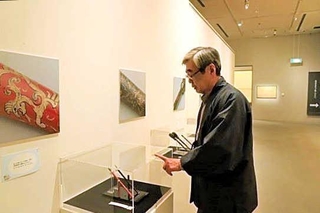展示された筆を見つめる公森仁さん＝広島県熊野町、筆の里工房