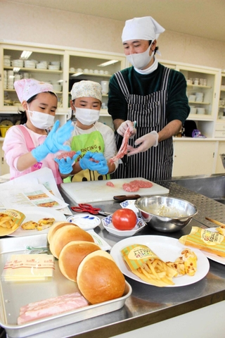 「お母さんのために」。ハンバーガーづくりに励む父と娘たち＝三木市総合保健福祉センター