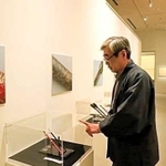 展示された筆を見つめる公森仁さん＝広島県熊野町、筆の里工房