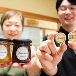 教育支援のためのＳコイン（右）と、コインがもらえる特製ジャム。右は山田勇人さん、左は岡本富恵さん＝三木市宿原、おうちごはんカフェそらまめ