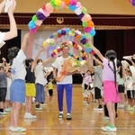 パリ五輪に向かうセルオド・バトオチル選手を花輪のアーチで送り出す児童ら＝緑が丘小学校