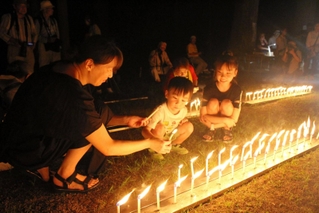 ろうそくに火を付け、阪神・淡路大震災の犠牲者を追悼する親子＝三木市志染町大谷