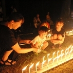 ろうそくに火を付け、阪神・淡路大震災の犠牲者を追悼する親子＝三木市志染町大谷