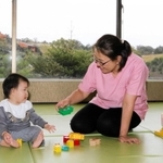 雄大な景色を見渡せるホテルのスペースで、預かった子どもと遊ぶ寺尾直美さん＝ネスタリゾート神戸