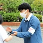投票を済ませた有権者に出口調査への協力を依頼する長谷川聖さん＝三木市緑が丘町中３