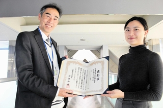 表彰状を手に受賞を喜ぶ県庁出向の蔡さん（右）と三木市縁結び課の清水さん＝三木市役所