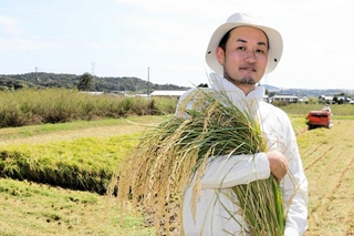 昨年１０月、稲を収穫する岩崎達也さん。耕作放棄地を耕した＝三木市久留美