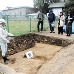 三木城本丸跡・二の丸跡で進む発掘調査の成果を説明する学芸員＝三木市上の丸町