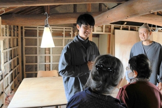 「心拍」を見学に訪れた地域住民に改装のポイントや今後の営業方針などを説明する藤本淳弥さん（左）＝三木市久留美