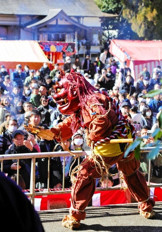 たいまつを手に参拝客の前で舞う赤鬼＝大宮八幡宮