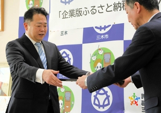 仲田一彦三木市長から感謝状を受け取るサムティの小川靖展社長（左）＝三木市役所