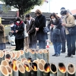 鎮魂の竹灯籠の前で黙とうする参列者＝１７日午後２時４６分、三木市末広１