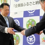 仲田一彦三木市長から感謝状を受け取るサムティの小川靖展社長（左）＝三木市役所