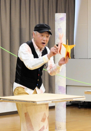 折り紙のキツネやウサギを演じ分ける南さん＝青山公民館