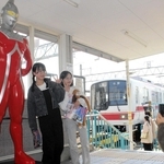 神戸電鉄志染駅に設置されたウルトラセブンの立像と記念写真を撮る利用者＝三木市志染町西自由が丘１