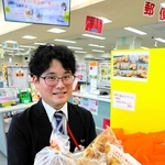 無人販売する焼きたてパンの詰め合わせを手に、来局者に購入を呼びかける三木郵便局の緒形友雅さん＝三木郵便局