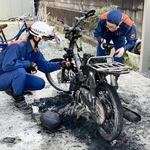 不審火で焼けたミニバイクを調べる消防署員＝三木市緑が丘町西１