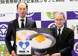 三木市に給食用として卵１２８０キロを寄贈することを決めた坂本産業の横尾勤総務部長（左）と大西浩志副市長＝三木市役所