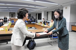 市学校給食審議会の水野千恵会長（右）に、給食費の改定について諮問する大北由美教育長＝三木市役所