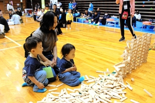 木のドミノを見つめる親子＝吉川総合公園