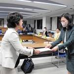 市学校給食審議会の水野千恵会長（右）に、給食費の改定について諮問する大北由美教育長＝三木市役所