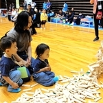 木のドミノを見つめる親子＝吉川総合公園