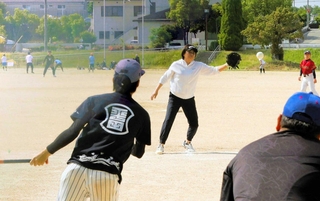 マウンドに上がって白球を追う元「三木クイーンズ」の田渕美香さん＝三木グリーンパーク