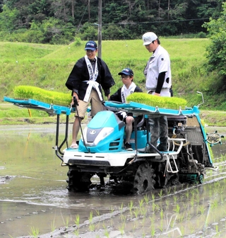 初めて田植え機のハンドルを握る大学生ら＝三木市吉川町冨岡